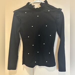 Black long sleeve sweater. Snug fit, with ruffle shoulders and a ruffle collar